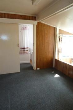  5 Bonney Street Deloraine TAS 7304 2 bedroom home with optional third bedroom or study Wood heating Galley kitchen Sunroom Shower over bath Private secluded backyard Lock up garage 