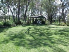  237B Northern Road  ROMA QLD 4455 Situated on 5 acres, in a very secluded area is this beautiful brick veneer home. A formal entry at the front leads to the elegant lounge room with huge lead lighting windows. The open plan living takes in the family and dining areas plus the spacious Tassie Oak kitchen boasting pantry, microwave box, appliance hideaway and big island bench. There is no shortage of space with 4 ample B/I bedrooms (ensuite in main) plus office, separate shower with Spa bath, fully screened rear verandah, ducted air conditioning and 2 way wood heater. 9m x 6m LU powered plus air conditioned garage with extra 6 metre extension, 2 bay carport , bird & dog cages, green house & established gardens with own gazebo. 
