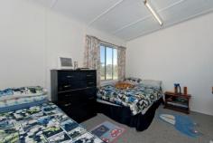  8 Short Street Dungog NSW 2420 With sweeping north-easterly views over Dungog and across to Coorei Hills and offering unlimited scope, this delightful cottage fibro and iron-roofed cottage on a gently sloping 847 sqm block represents an excellent entry into the housing market or a sound investment option. Light-filled rooms with generous proportions provide a comfortable, relaxed ambience. There are three queen-size bedrooms, master with wall-mounted air-conditioner. Centrally located, the family bathroom has benefited from an update and includes vanity, bath, shower and toilet. The spacious, remodelled all-electric kitchen with ample bench and storage space plus breakfast bar overlooks the family meals area and informal lounge, its wall-length windows flooding the space with natural light and drawing the outside in with uninterrupted views of the delightful rear garden, in-ground swimming pool and beyond. A second living room boasts slow-combustion heating and wall-mounted air-conditioning. There is also a dedicated study/home office. The home is surrounded by established trees and low maintenance lawns and gardens that offer further scope for the keen gardener. The rear garden is fully fenced providing a safe, flat play area for children and pets as well as a delightful relaxation area from which to take in the views. An additional building attached to the home lends itself to a workshop or possible conversion to guest accommodation or student's retreat. Further features include complete re-wiring within the past three years, carpeted bedrooms and formal living zones, polished floorboards in family meals area and informal living zone, separate laundry with external access, fresh neutral palette throughout, second toilet in adjoining building and two car garage.  Current leasing on a month by month basis realising a rental return of $200 per week confirms the property's investment credentials while allowing for availability for owner-occupiers. With its convenient location within walking distance to Dungog's vibrant shopping strip, primary and high schools, sporting facilities and CountryLink Station and only a short drive to the region's major commercial centres of Raymond Terrace, (35mins), Maitland (45mins) and Newcastle (1hr), this is a home that offers comfortable living as is but with unlimited scope for further enhancement.   