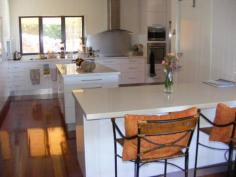 24 Reifs Rd Tablelands QLD 4605 If you have always wanted to wake up to stunning views, this could be for you. This beautiful property has been built on the Tablelands overlooking Murgon. A sweeping concrete driveway leads to this stunning property which has been designed and built with space and flow. Expansive living areas with wonderful high ceilings and polished timber floors. Spacious kitchen with island bench, stainless steel appliances, dishwasher and quality base wall and pantry cupboards. 4 bedrooms 3 of which open onto verandahs. A craft room, office and family room. Ensuite and 2 further bathrooms one on each level. Windows on the first floor offer extensive views. Internal stairs and a dumb waiter lead from the ground to the first floor. Private and peaceful living. Established gardens. Detached triple garage and workshop. Single garage at house with remote lift door. 