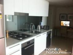 12104 8 Harbour Rd HAMILTON Qld 4007 This beautiful modern two bedroom apartment could be yours. This apartment is light, airy and embraces the vast views of Hamilton, Ascot and out as far as Moreton Bay through the double glazed floor to ceiling windows. The fully carpeted open plan living area embraces a large linear styled kitchen with quality Omega appliances. The master bedroom features an ensuite, the second bedroom features floor to ceiling windows, built in robe. With all of these features it is a rare find and will not last. This apartment also comes with 2 car parking spaces and use of all the Hamilton Harbour facilities including the beautiful resort style lap pool and BBQ area surrounded by lush tropical gardens. 