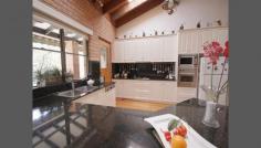  Roseville NSW  2069 There is plenty of scope for the growing family in this solid full brick family home. Architecturally designed and built in 1979, this home offers spacious formal and informal living areas. Full brick construction situated in a quiet child safe cul de sac with peaceful bushland views of Ku-ring-gai National park on 825 (approx) m2 of land. Features include: * Generous sized main bedroom with ensuite  * 3 additional bedrooms, two with large built in robes * Formal dining room flows to lounge with 16' cathedral ceilings  * Modern kitchen with granite benches and plenty of cupboard space * Large open plan family area adjacent to the kitchen including a separate area with wood burning slow combustion fire * Beautiful black butt timber floors throughout the family and bedroom areas  * Spacious double lock up garage with level entry to the family room and kitchen * Downstairs is a large area suitable for home business, in law accommodation or self contained granny flat the option is yours 