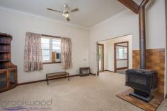  28 Hovea Cres, Wundowie WA 6560 It’s the little things that make a big difference in this modest three bedroom one bathroom home, like gleaming, newly polished Jarrah floorboards and high ceilings that create a sense of space and comfort. It also features a large retro kitchen, two cosy living areas, a carport/shed and rear access to this 1,012sqm block, which is in easy walking distance to all of the town’s major amenities.  3 bedrooms 1 bathroom  Modest fibro home  Spacious retro kitchen  Cosy living room, s/c fire  Lovely refurbished lounge  Polished Jarrah boards  Elevated timber porch  Detached carport/shed  1,012sqm rear access blk  Walk to school, shops, park  The main open living area is carpeted with a central slow combustion fire that efficiently warms the whole house and a rustic timber bar in the corner. Gleaming polished Jarrah floorboards in the recently refurbished formal lounge room are paired with high ceilings, large street-facing windows and a built-in electric heater to provide a comfortable secondary living space.  The ample, eye-popping orange-yellow benchtops, timber-look cabinetry and Metters wood stove give the surprisingly spacious kitchen a cool retro vibe. It also has a freestanding electric oven and cooktop. The rear sleep-out houses the laundry, a bathroom with separate toilet off to one side and a third bedroom. It has a sliding door into the large carpeted master bedroom. Bedroom two is off the living room and has a robe alcove and Jarrah floorboards.  Watch the world go by from your seat on the elevated front timber porch or entertain out the back under the verandah, which spills out to a brick paved area adjacent to a shadehouse. There is a single carport/shed at the end of the side driveway and a few additional structures in the large yard, which has rear access off Leschenaultia Road. This is a great location in easy walking distance to the shops, school, sports ovals and so much more.  Wundowie is one of the first true country towns on the eastern fringe of the metropolitan area and as such contains all the essential services needed for a self-supporting community, including a primary school, police station, medical centre, ambulance station, fire brigade, community centre, library, post office, day care, fantastic sporting facilities and more.  There’s no denying this property has been cared for. It has good bones, some great features and is incredibly affordable. So if you’re looking to get started with your own home or you’re looking for a smart investment, don’t ignore this great opportunity.  To arrange an inspection of this property or for a no fuss, fair dinkum approach to local real estate call ‘True Blue’ local agent Sam Blackwood on 0408 308 360.  BE SEEN - BE SOLD - BE HAPPY  Do you want your property sold? For professional photography, local knowledge, approachable staff, a proven sales history and quality service at no extra cost call the Brookwood Team. 