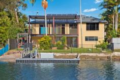  50 Jacaranda Avenue Two Heads West NSW 2485 Waterfront Home with Pontoon and Sandy Beach/ Boat Ramp Defined by a wonderful sense of understated waterfront location, this well presented home reveals a family environment as stylish as it is comfortable. It's enviably positioned within a level walk of cafes, shopping choices and a reserve next door. Keep the guests/teenagers or parents downstairs as it's a perfect get away or private work space. - Open plan design creates flexible living and dining spaces to enjoy sunrise and sunsets - Sliding doors open to all-weather alfresco sun washed entertaining spaces - Peaceful easy care back yard lined with scattered trees and gardens, pontoon and boat ramp - Granite/two pack finished kitchen, large pantry, gas stove top cooking and bonus water views - Three upper level bedrooms all have built in wardrobes, plus ground floor fourth with separate lounge area , bathroom and kitchenette - Master boasts a large window with water views and air-conditioning - Timber flooring upstairs, air conditioned lounge/dining  - Downstairs easy care epoxy floor effect over concrete floors, bathroom with large tub to relax in after a day on the water  - Large workshop/store room/internal entry to garage - Steps from leafy reserves, and bus stop nearby to Coolangatta beaches and Kingscliff Tafe  -Solar hot water and power 