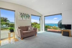  1 Tanina Mews Kingston Beach TAS 7050 $1.1 M+ Private, low maintenance established gardens and sweeping views await you at this beautifully presented property in Kingborough's most popular location. Architecturally designed and positioned to enjoy beach and river vistas this lifestyle property welcomes sunlight into every room increasing its thermal efficiency and lowering energy usage. Tanina Mews is a well held, private location and this home has seen only 2 owners in its 24 years. The contemporary design characteristics will ensure that it remains as relevant in the future as it was at inception. At entry level there is a large lockable double garage with workshop, storage and single carport adjacent. A beautifully appointed and tiled entrance is found through the front door and timber and steel stairwell leads you to the main level of the home. From here the vast views become apparent through large glass windows positioned cleverly so that the beach is never far from your mind. High curved ceilings feature through the generous living, kitchen and dining areas as natural light filters through from every direction. This level of the home is perfect for busy families and entertaining both inside and out. There is a north facing alfresco deck space opening from the kitchen which would be a perfect space for summer breakfasts and a protected Barbecue area at the rear. The large living space is complemented by an equally charitable rumpus room that could be easily converted to a fourth bedroom with both zones accessing the undercover entertaining space through glass sliding doors. The Eastern wing of the main level houses two generously proportioned bedrooms that have a beautiful leafy and peaceful feeling, built in wardrobes and inbuilt desks. The journey to these rooms is amazing. A wide hallway is completed with a floor to ceiling window that leads the eye across the River Derwent to Hobarts Eastern Peninsula and beyond. The main bathroom and laundry are found at the opposing end of the hall way and positioned to be close to all living and accommodation areas. Completing this home perfectly is the parent's master suite that is found on the 3rd level. Lovely Tasmanian Oak flooring features alongside a large walk through robe, study and ensuite. The elevation allows its occupants privacy, tranquillity and views but really that is what this home is all about. 