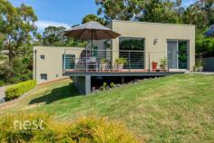  1 Tanina Mews Kingston Beach TAS 7050 $1.1 M+ Private, low maintenance established gardens and sweeping views await you at this beautifully presented property in Kingborough's most popular location. Architecturally designed and positioned to enjoy beach and river vistas this lifestyle property welcomes sunlight into every room increasing its thermal efficiency and lowering energy usage. Tanina Mews is a well held, private location and this home has seen only 2 owners in its 24 years. The contemporary design characteristics will ensure that it remains as relevant in the future as it was at inception. At entry level there is a large lockable double garage with workshop, storage and single carport adjacent. A beautifully appointed and tiled entrance is found through the front door and timber and steel stairwell leads you to the main level of the home. From here the vast views become apparent through large glass windows positioned cleverly so that the beach is never far from your mind. High curved ceilings feature through the generous living, kitchen and dining areas as natural light filters through from every direction. This level of the home is perfect for busy families and entertaining both inside and out. There is a north facing alfresco deck space opening from the kitchen which would be a perfect space for summer breakfasts and a protected Barbecue area at the rear. The large living space is complemented by an equally charitable rumpus room that could be easily converted to a fourth bedroom with both zones accessing the undercover entertaining space through glass sliding doors. The Eastern wing of the main level houses two generously proportioned bedrooms that have a beautiful leafy and peaceful feeling, built in wardrobes and inbuilt desks. The journey to these rooms is amazing. A wide hallway is completed with a floor to ceiling window that leads the eye across the River Derwent to Hobarts Eastern Peninsula and beyond. The main bathroom and laundry are found at the opposing end of the hall way and positioned to be close to all living and accommodation areas. Completing this home perfectly is the parent's master suite that is found on the 3rd level. Lovely Tasmanian Oak flooring features alongside a large walk through robe, study and ensuite. The elevation allows its occupants privacy, tranquillity and views but really that is what this home is all about. 