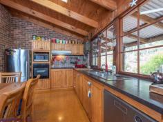  15 Milligan Road Parkerville WA 6081 $699,000 Come home to the beauty of nature with this 3 bedroom, 2 bathroom brick and iron home. The 1983-built Kentucky Homes residence is in perfect harmony with its natural 5-acre landscape and offers fantastic outdoor living and entertaining on the wide, elevated verandah. A floorplan that delivers formal and informal living gives you the flexibility to utilise spaces in a way that suits your lifestyle and the seasons. 3 bedrooms 2 bathrooms 1983-built brick and iron High pine-lined ceilings Open family and kitchen Formal lounge and dining Junior wing with activity Elevated, shaded verandah 4-car carport + workshop Natural 5-acre cul-de-sac Perfection in Parkerville Homes that have only ever known one owner are invariably imbued with love and an atmosphere of instant welcome – a sense of ease and contentment envelopes this 1983-built brick and iron home. From the private cul-de-sac address and the soothing natural setting to the warm, well-designed home with exposed brick and high ceilings, this property is a lesson in living lightly in the Hills. A wrap around verandah paved with bricks draws you to an expansive alfresco entertaining area and into the open plan family room, and kitchen arranged at the centre of the home. Exposed brick, a slow combustion fireplace and high, pine panelled ceilings deliver a cosy and airiness. A brick surround houses a slow combustion fireplace in the family room and an open fireplace in the formal dining and lounge room to create a central heat bank. Cork floors and pine cabinetry give the kitchen an organic style while electric hotplates, a wall oven and dishwasher fashion a user-friendly space with a large pantry. To one side of the central living area is the formal dining and lounge room. A ceiling fan and open fireplace ensure this space is ready for year-round entertaining while high ceilings and views of grass trees and eucalypts fashion a serene second living area. Arranged across the eastern face of the home is the main bedroom suite consisting of a large bedroom, walk-in robe, ensuite and private study. Reverse cycle air-conditioning and a ceiling fan manage climate control in this separate adult zone. A good-size study offers a private retreat that could be styled as a secluded library or spacious dressing room. A design that allows areas of the home to be closed off when not in use makes this home a great fit for young families, those with teens and empty nesters who like to have guests.  A separate junior wing at the western end of the home contains two junior bedrooms, a family bathroom and a large activity/studio room opening to the verandah. The large activity/studio is suited to various uses. Light-filled and looking out to the south, this space would make a terrific activity room, studio or crafting room. Extending out from the activity room is a wide alfresco entertaining area with a deep gabled roof extending low on the western edge. This elevated and paved space provides a beautiful outdoor dining area or a fabulous place to sit and absorb the beauty of your surroundings. Towards the front of the property are a large powered workshop, separate storage area and a 4-car carport. The home benefits from both scheme and bore water and has sprinklers fitted to the roof. Everything you imagine should be a part of Hills living is here: a private natural setting, a charming, comfortable home with a flexible floorplan and fabulous outdoor living just minutes from the bustling Mundaring Village. 