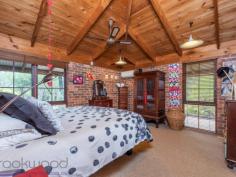  15 Milligan Road Parkerville WA 6081 $699,000 Come home to the beauty of nature with this 3 bedroom, 2 bathroom brick and iron home. The 1983-built Kentucky Homes residence is in perfect harmony with its natural 5-acre landscape and offers fantastic outdoor living and entertaining on the wide, elevated verandah. A floorplan that delivers formal and informal living gives you the flexibility to utilise spaces in a way that suits your lifestyle and the seasons. 3 bedrooms 2 bathrooms 1983-built brick and iron High pine-lined ceilings Open family and kitchen Formal lounge and dining Junior wing with activity Elevated, shaded verandah 4-car carport + workshop Natural 5-acre cul-de-sac Perfection in Parkerville Homes that have only ever known one owner are invariably imbued with love and an atmosphere of instant welcome – a sense of ease and contentment envelopes this 1983-built brick and iron home. From the private cul-de-sac address and the soothing natural setting to the warm, well-designed home with exposed brick and high ceilings, this property is a lesson in living lightly in the Hills. A wrap around verandah paved with bricks draws you to an expansive alfresco entertaining area and into the open plan family room, and kitchen arranged at the centre of the home. Exposed brick, a slow combustion fireplace and high, pine panelled ceilings deliver a cosy and airiness. A brick surround houses a slow combustion fireplace in the family room and an open fireplace in the formal dining and lounge room to create a central heat bank. Cork floors and pine cabinetry give the kitchen an organic style while electric hotplates, a wall oven and dishwasher fashion a user-friendly space with a large pantry. To one side of the central living area is the formal dining and lounge room. A ceiling fan and open fireplace ensure this space is ready for year-round entertaining while high ceilings and views of grass trees and eucalypts fashion a serene second living area. Arranged across the eastern face of the home is the main bedroom suite consisting of a large bedroom, walk-in robe, ensuite and private study. Reverse cycle air-conditioning and a ceiling fan manage climate control in this separate adult zone. A good-size study offers a private retreat that could be styled as a secluded library or spacious dressing room. A design that allows areas of the home to be closed off when not in use makes this home a great fit for young families, those with teens and empty nesters who like to have guests.  A separate junior wing at the western end of the home contains two junior bedrooms, a family bathroom and a large activity/studio room opening to the verandah. The large activity/studio is suited to various uses. Light-filled and looking out to the south, this space would make a terrific activity room, studio or crafting room. Extending out from the activity room is a wide alfresco entertaining area with a deep gabled roof extending low on the western edge. This elevated and paved space provides a beautiful outdoor dining area or a fabulous place to sit and absorb the beauty of your surroundings. Towards the front of the property are a large powered workshop, separate storage area and a 4-car carport. The home benefits from both scheme and bore water and has sprinklers fitted to the roof. Everything you imagine should be a part of Hills living is here: a private natural setting, a charming, comfortable home with a flexible floorplan and fabulous outdoor living just minutes from the bustling Mundaring Village. 