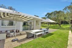  2000 Peats Ridge Road Calga NSW 2250 Set against a stunning natural rock wall backdrop this property is a green crucible of 6 cleared and extensively pasture improved acres, fenced, irrigated and landscaped for those seeking the peace and tranquillity of a private rural lifestyle just approximately 30 minutes’ drive to Wahroonga and the M1. The property offers direct access to horse riding trails and to Glenworth Valley. The owners have laboured intensively at developing the landscape to create a beautiful, green blanket of quality, perennial pasture. There is a river sand arena at the top of the property, with excellent drainage and two dams provide great water for irrigation and stock. A central main dam complete with cascading waterfall makes a stunning feature, overviewed by the delightfully presented and recently renovated, double brick, 3 bedroom and study home, featuring large central living areas with polished concrete floors, high ceilings, central fireplace and beautifully presented outdoor areas. There is central air-conditioning and 2 tastefully renovated bathrooms providing a high degree of comfort. Views from the renovated kitchen and other areas are extensive across all of the property. Landscaping around the home has been carefully designed and constructed with extensive use of massive sandstone blocks to create retaining walls, both at the front and rear of the home and wonderful flat outdoor living spaces. A white picket fence around the house yard enhances the perfect appearance and offers child and animal proof security. Water on the property is abundant with spring water, rainwater storage and two dams to provide all stock, irrigation,and domestic needs. For those not intending to live permanently at the property, the two large paddocks have ample fodder for three horses and the two dams ensure animals also have plenty of drinking water. A large, renovated shed with 3-phase power offers abundant storage space for vehicles and horse floats along with a great area for tack and feed room and other horse facilities. 