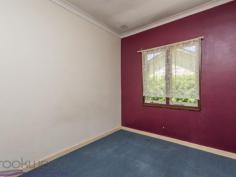  38 Lobelia Avenue Wundowie WA 6560 $150,000 Exhibiting an honest charm with its high ceilings and well-proportioned rooms this 1950 Wundowie original, although faded and in need of TLC, is an excellent example of unfulfilled potential. Occupying an elevated position on a 1012 sqm lot with a large, shady backyard, the 2 bedroom, 1 bathroom home is ready and waiting for someone to appreciate and uncover its allure. • 	 2 bedrooms 1 bathroom • 	 1950-built fibro and tile • 	 Renovators’ delight • 	 OP family/kitchen/meals • 	 High ceilings orig windows • 	 Activity/studio/sleepout • 	 Screened rear verandah • 	 Lge shady north face yard • 	 Elevated 1012 sqm block • 	 Walk town, school, pool Roses and lavender surround the front steps of this original Wundowie cottage. The fibro and tile home sits on an elevated lot and boasts a front porch with views to nearby bushland and across to a distant ridge. An open plan family room, kitchen and meals area offers the first glimpse of the potential of high ceilings and original windows. The carpeted family room enjoys views to the south and features an ornamental brick fireplace. The kitchen/meals area is large enough to accommodate a table and fitted with a U-shaped bench and freestanding oven. A reverse cycle air conditioner in the family room provides year-round climate control. Adjoining the kitchen is an additional living space with the potential of forming part of a larger, renovated kitchen. With access to the screened porch and backyard, this good-sized room could also be styled as a study or activity space. The well-proportioned main bedroom sits at the front of the home with reverse cycle air conditioner, the room has  windows to the south and is shaded by a tall pepper tree. Both bedrooms are carpeted and benefit from high ceilings. A family bathroom with over-tub shower and vanity and a separate W.C. are arranged off the walk-through laundry. A brick-paved verandah edged with raised garden beds leads from the screened porch to the spacious backyard where a garden shed, and carport provide handy storage space –  a drive-through carport sits at one side of the home. The country-style verandah looks out to established fruit trees and lush grape vine. Wundowie is a well-serviced country town with the infrastructure needed for a self-supporting community, including a police station, medical centre, ambulance station, fire brigade, community centre, library, post office, daycare, fantastic sporting facilities, public swimming pool and more.    There is no denying that hard work is required to make this faded rose bloom again, but sharp pricing and a great position make this a tempting prospect. To arrange an inspection of this property and experience the real difference in real estate call Mr Real – Nigel Williams – 0417 988 680. 