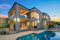  7 Currie Place Kardinya WA 6163 Designed by Oswald Homes with the highest quality throughout and positioned on one of the highest points in Kardinya, this elevated home captures the north facing panoramic views of the Perth City skyline and beyond. Positioned in a quiet cul-de-sac comprising 929sqm of Green Title land which has duplex subdivision potential to create a rear lot comprising 351sqm of land including the driveway down the side of the house with keeping the existing home and pool. This rare opportunity provides flexibility of enjoying this additional outdoor space and abundance of parking options, building an additional residence at the rear or land banking for the future. This stunning home has been cleverly designed for both downsizers and growing families alike as the floor plan offers the ability for a couple to live on one level. The gourmet chef’s kitchen, open plan lounge and dining area, grand master bedroom suite, theatre room and alfresco entertaining all on the same level that you enter from the double garage. Comprising over 400sqm of internal living area, there are multiple living areas, five spacious bedrooms, dedicated study/6th bedroom, three sumptuous bathrooms and two powder rooms. There is an abundance of storage options and generous wardrobes throughout. There are two outdoor entertaining areas – a cedar lined alfresco that flows via bi fold doors from the main living area plus a ground floor undercover alfresco next to the sparkling swimming pool. This home is complete with ducted vacuum, timber floors, solar power, ducted reverse cycle air conditioning and reticulated gardens. Conveniently positioned only minutes to Murdoch University, Fiona Stanley Hospital, excellent local schools, parks and paying fields, Kardinya Park Shopping Centre, cafes, shops and bars plus easily connected on transport. Fremantle, Perth Beaches and Perth CBD is within 15 minutes drive. This home is ready to move straight in and enjoy! For further details please contact Renee Banovich on 0409 647 341. 