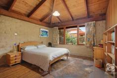  7 Drew Court Beechworth VIC 3747 $780,000 to $810,000 This architecturally designed mud-brick home is quietly tucked away and is surrounded by colourful native gardens. Wide verandahs invite you into this special home. The spacious living and dining area feature polished slate floors, soaring timber ceilings and solid exposed beams. Large windows and French doors allow the outside in. An attractive Coonara-style wood fire is a focal point, whilst there is hydronic floor heating to maintain a constant, comfortable temperature through winter. Wooden and mud-brick walls co-exist with native timber cabinetry and benchtops bringing character to the well-equipped kitchen, complete with a walk-in pantry, electric cooking and dishwasher. A second living and dining with skylights can be sectioned off from the main living room. The generous master bedroom has large built-in robes and accesses a beautifully styled ensuite with shower and vanity. An equally spacious second bedroom has large built-in robes, and like the master, is drenched in morning sunlight. A two-way toilet is accessed from either the ensuite or the family bathroom. This second bathroom features a shower, small bath and timber vanity. The large laundry, doubling as a utility/mud-room has plenty of storage - there is no shortage of storage options in this home! A wide craftsman-built Jarrah staircase ushers you to the upper floor. Quietly situated here is the third bedroom. Complete with its own toilet and vanity, this is a truly special place with a private deck. You will spend many hours here amongst the treetops and above the rooftops. Outside a secure shed will house your garden implements, the bird-attracting native gardens are beautifully established whilst there is plenty of space for vegetables. 
