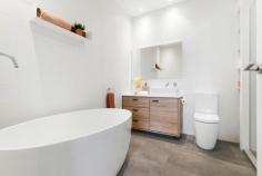  129 Westbourne Rd Kensington VIC 3031 $960,000 - $1,050,000 Showcased over three levels, this three bedroom two bathroom home has been fully updated to the pinnacle of quality, convenience and comfort. With parkland at the front door, tall trees providing shade and ringed by community greenspace, this immaculate residence is handy to everything cosmopolitan Kensington has to offer. The ground floor shines with engineered timber flooring, Daikin inverter and open plan design with glass sliding doors to the private courtyard featuring vertical garden and BBQ gas connection. The kitchen boasts Bosch appliances and a stone top waterfall island bench. Upstairs finds a luxurious main bedroom with walk-in robe and ensuite with freestanding bath and frameless walk-in rain shower. A second large bedroom has BIRs and an elongated balcony, with the top level hosting a third bedroom with a study nook offering expansive views. The central bathroom is fully tiled and contains a modern vessel sink, while a separate and sizeable home office sits alongside the single garage with automatic entry. Other quality inclusions are a downstairs powder room, under stair and roof storage, European laundry, WIFI controlled ducted heating, air conditioning units in all the bedrooms, Rinnai instantaneous hot water, quality window treatments and plush carpets. 