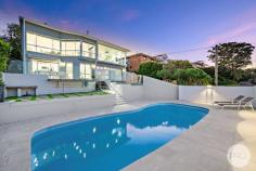  24 Mulubinda Parade Corlette NSW 2315 $2,950,000 - $3,245,000 This majestic, master-built residence located in one of Port Stephens most sought-after locations combines spectacular panoramic water views over Port Stephens with an outstanding interior design. Solid in its suspended concrete construction and superbly crafted in an elevated north facing position, this residence comprises of four bedrooms of accommodation, three bathrooms, various living areas and captures stunning 180-degree views from multiple levels and areas throughout the home. The open plan layout melts the kitchen area with grand living and dining spaces in a light filled ambience with blue vistas through a premium panoramic window front and sky lights. Exclusivity and quality at the highest level wherever you look. A high end kitchen built by the award winning team at Latham Kitchen designs comes equipped with a one-piece stone bench top, automated cupboard doors, SMEG appliances like induction cook top, dual ovens, and plate warmer as well as a built-in coffee machine. Kitchen cupboards are fitted with internal drawers for easy access and organised storage. You'll also find an adjoining Butler's Pantry with integrated fridge and further preparation space for the Master Chef's or entertainer. Nothing has been missed when it comes to this premium gourmet design. The bathrooms come with exceptional comfort and style. Designed with care and thought, they include underfloor heating, heated towel rails, generous shower recess complete with niche and linear drains, an elegant free-standing bathtub, and are tiled floor to ceiling with feature walls and floating vanities. When it comes to outdoor living, spend the summer entertaining on the balcony or on the terrace where you overlook the swimming pool and take in the panorama across this magnificent waterway. These views are unbeatable, and you are only 580m from the water's edge. Indoor comfort is also taken care of with solar hot water, ducted air conditioning, an open fireplace and sea breezes. The layout of the residence allows for separate living on the lower level, if so desired, and comes complete with bedroom, bathroom, kitchenette and living area. This space can be accessed internally or made private with external access. Perfect as a retreat or an additional income earner. Dual street frontage provides additional access via the cul-de-sac of Myan Close to the off-street parking spaces as well as the spacious double garage, workshop, and storage area. 