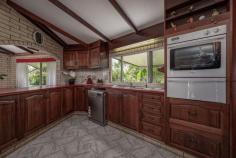  10 Marco Cl Pin Gin Hill QLD 4860 $950,000 - 3 distinct dwellings designed by a master builder - Over 10 acres - Infinity pool - Water tank of 62,000 litres - Dam and creek - Vegetable garden - Dual entrance - 5KW solar system - Generator fallback - Vast rainforest estate - Only minutes from town - Peaceful and private - Magnificent views - Riding lawnmower - Gym - 1 hour from international and domestic airports Property Specifics This one-of-a-kind property was lovingly created by a master builder who was way ahead of his time. Being on the cutting edge of natural health and sustainable living It was designed as a luxurious survival block for when the shop shelves ran out of supplies. 10.5 acres, almost an entire valley, with golf course-style greens and about 4 acres of old growth rain forest up the hillsides and around the creek. Yes, you will have your own valley with a dam for swimming and/or farming. Because the rich volcanic soil lacks clay, the dam was built with a heavy-duty liner and remains full all year. She is 18 feet deep, straight off the dam wall, and has a syphoning system with a one-way valve installed so that it syphons from the bottom of the dam, flowing under rather than over the spillway. fruit trees that have been established, including rare exotic fruits. Buildings The main house is constructed of brick and tile, with cyclone rods anchoring it to the hillside. It has been through two Category 5 cyclones with little damage and has a shelter for cyclones. There are three bedrooms, all with built-in robes, as well as an office. Rest rooms are available both upstairs and downstairs. A stunning Tasman oak kitchen and open-plan living room bring the entire family together. sunken lounge with curved reclining loungers. The house was built for the tropics and is completely air-conditioned with split systems. If you'd rather have a breeze than air conditioning, it also has a cost-effective central exhaust fan that lets the breeze come in through any window. The master bedroom opens onto the veranda, which connects to the outdoor BBQ area and the stunning infinity pool. During the day, the views from here are breathtaking. And floating in the pool at night, when the water is spilling over the illuminated waterfall, gazing up at a billion stars is like, "Wow." Just wow! The lockable 8-car garage is also a cyclone shelter, has its own bathroom and toilet, and houses a monstrous workshop with 3-phase power and a gymnasium with views of the vegetable garden. A very spacious, fully self-contained single-bedroom unit is located at the far end of the main house. Fully air-conditioned and tiled throughout, with rainforest views. There is a new gas stove, a built-in laundry room, and a private deck. The dual entrance allows for complete privacy and is wheelchair accessible. boat or machinery shed with a high roof. It easily accommodates two trailer sailors or tip trucks. Underneath is a mind-boggling 62,000-liter concrete water tank. The entire property can be easily converted from rainwater to city water. Finally, there is a separate, secluded two-bedroom house in the valley with a view of the dam. A separate driveway provides access. It has a two-car garage and a garden shed. ceiling fans and louvres throughout to capture the breeze while repelling rain. The possibilities for this location are limitless; let your imagination run wild. As you might expect, no expense was spared during the 30+ years it took to bring this creation to life. The master who made it has passed away, and it is too large for his family. Because much of the furniture was handcrafted and designed specifically for the house, it will be sold fully furnished. 