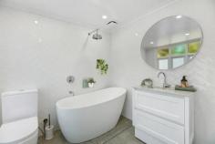 81 Railway Ave Bundanoon NSW 2578 $1,395,000 Set in a prime, elevated position ensuring privacy and perfect northern sunshine, this gorgeous timber cottage has been lovingly restored and will pull at your heart strings from the sun soaked entry to the rear garden. Highly sought after northerly aspect to the entry and sunroom which accesses the generous centrally located living / dining area via double sliding doors with fireplace and split a/c. The galley kitchen overlooks the garden and rear sandstone terrace perfect for entertaining and offers a gas cook top, electric oven, dishwasher, large walk in pantry and flows directly off the living space. All three bedrooms are doubles with built ins plus cute ensuite off the main or guest room whilst the remaining two beds are serviced via the stunning NEW bathroom with egg bath, shower over bath, wc, gorgeous marble topped vanity and herringbone tiled walls. The European style laundry has also had a full makeover and makes excellent use of the space with a frosted glass door to the rear terrace and clothesline. Further features of this charming cottage are the high ceilings, timber floor boards throughout, freshly painted interior / exterior and roof, timber windows and newly renovated main bathroom. Two street frontages plus a large level parking bay at the rear with double carport and space for a new garage or workshop accessed via William Street, leaves scope for more additions if needed. The stunning tiered garden with established hedges, trees and level grassed areas ensures ongoing privacy, space for the family and pets with the added bonus of a lovely local outlook. Only metres to the village shops, station and school this charming cottage could be your tree change, downsizer or weekend getaway.  