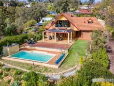  49 Hilltop Pl Kelmscott WA 6111 $799,000 This simply stunning character 2 storey home will delight ! 4 bedrooms and 2 bathrooms, double workshop and below ground pool set in total privacy with breathtaking city and valley views, all on a super sized 2050 sqm block… In short the perfect hills package. The private residence of a local artist, this property oozes charm and has been built to a very high standard. All of the room sizes are very generous, you just feel free to enjoy the space. The magnificent lounge ( approx 6m x 7 m ) has warm timber floors and a wood heater. This space flows effortlessly through multiple french doors out to the exceptional undercover patio built alongside stunning below ground pool. Everything here takes in the gorgeous uninterrupted views. The kitchen is huge too, incorporating an informal meals area, while the super sized formal dining room (around 5m long) also with lovely timber floors, will host some spectacular dinner parties I’m sure ! Oh yes ! there is a beautiful view from here too. Upstairs can be your retreat. Comprising of the master bedroom and en-suite, plus a bedroom or study. Plenty of living area up here as well with a huge family room with vaulted ceilings plus a cute little balcony. You guessed it, VIEWS, VIEWS and more VIEWS. The block is sloping but has been well established and very usable. Excellent rear driveway access to a double garage plus a separate double carport plus room for trailer or what have you. There are some lovely shady sitting spots around the property to read a book or enjoy your morning coffee. Some great spaces for the veggie patch, chickens or just enjoy the garden. An absolute bonus here is the north facing aspect. Access to the delightful sun in winter is so important. (those of us living on the south side of the hill know this) Your veggies will grow easily and you can see the sunset every day from here. After sunset, while entertaining friends or family the view turns to twinkling lights from the Kelmscott township all the way to the stunning City skyline. WOW!!! Of course, all the features you would expect including, reverse cycle air conditioning, alarm, powered double workshop, PV solar and solar HWS. This is a rare find and will attract enormous interest so make sure you see it and secure it for your family. 