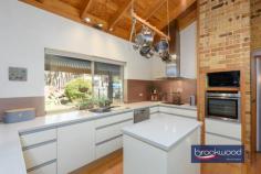  930 Houston St Mount Helena WA 6082 $849,000 Escape into the enchantment of nature and days filled with birdsong and the antics of native wildlife. This 4-bedroom, 2-bathroom home embodies Hills living with a stylish modern kitchen, soaring, timber-lined ceilings and fully tiled bathrooms. A central open plan, flanked by adult and junior wings, radiates an air of grandeur equalled by the natural splendour of the 4.34-acre site. 4 beds 2 baths plus study 1991-built brick and iron Stylish open plan kitchen Soaring ceiling exp beams Separate junior bed wing Wrap-around verandah 12m x 6m pwd workshop 6 kW solar array bore tanks Natural 4.34-acre block Close schools Mundaring Step inside the open-plan living zone to discover a faultless merging of natural and built environments. Morning sun through a leadlight window casts colourful patterns on the floor, soft, natural tones and organic textures echo the surrounding landscape. Raked ceilings lined with honey-toned timber bring a sense of space and stillness to the heart of this home. A sunken den – or study – and built-in bar arranged at one corner of the family room ensure a welcoming atmosphere with ample space for socialising. Add to the picture a slow combustion fire, reverse cycle air-conditioning, a floorplan that flows to the outdoor entertaining area and spa, and a kitchen that’s sure to inspire culinary triumphs, and it’s easy to visualise years of making memories with friends and family. The kitchen boasts an open-plan layout and features a stone waterfall-end benchtop with integrated breakfast bar. Equipped with an electric cooktop, wall oven and dishwasher, this cooks’ haven is sure to inspire gastronomic triumphs. Abundant storage is provided by deep drawers, tall cabinets, and a central island. A paved and sheltered outdoor entertaining zone extends from the open-plan kitchen and meals area. Set against a painterly landscape of dappled light, lush lawn and the sculptural forms of tall eucalypts – a vista also available from the decked, above-ground pool and spa – this oasis of calm and nature’s magnificence is an unbeatable setting for getting together with friends and family or simply whiling away a lazy afternoon. At the west of the plan is a restful parents’ retreat comprising a large bedroom, a walk-in robe and an ensuite. A sliding door onto the front verandah leads to an idyllic setting for sharing a quiet breakfast together. Three junior bedrooms, a shared family bathroom and separate WC form the junior wing at the opposite end of the home. A walk-through laundry completes the layout in the junior wing. Towards the southern boundary, a powered workshop awaits those with a project in the works – or on the horizon. Drive-in access and an adjoining concrete apron make this a practical workspace. Space for vegetable gardens, fenced holding yards with shelters and a chicken coop offer opportunities to fully embrace a Hills lifestyle. Hours of adventurous play and discovery await with more than 4 acres to explore, further afield, a local access track leads to kilometres of walking and riding along the Heritage Trail. Immersed in a breathtaking natural setting and bordering a serene reserve, this impressive property rests gently in its setting and displays an effortless combination of timeless charm and modern elegance. 