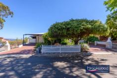  19 Oxley Pl Darlington WA 6070 $1.24 MILLION Dappled light dances along a quiet, secluded cul-de-sac leading to the carriage driveway of this large family home with breathtaking views, zoned living, expansive outdoor living and entertaining space, a separate studio and a below-ground pool with a gazebo. A quintessential Darlington property with exceptional views, the home boasts generous proportions, formal and informal living and views that sweep from Boya across the plains to John Forrest National Park. • 	 5 bedrooms 3 bathrooms • 	 1984-built brick and iron • 	 Formal lounge and dining • 	 Open-plan kitchen/meals • 	 Activity/media w projector • 	 W-around alfresco w blinds • 	 Freestanding studio space • 	 Heated below-ground pool • 	 2122 sqm dual frontage lot • 	 Secluded Hillside location Step inside to discover generously proportioned living spaces that seamlessly blend formal and informal areas, all enhanced by breathtaking views with almost every window framing exceptional vistas and bringing the outdoors in with abundant natural light and beauty. A separate junior wing comprising three bedrooms and a family bathroom is arranged at the front of the plan, along with a study with an entry from the garage. An ensuite bedroom with a corner window capturing fantastic views across the pool to the horizon offers ideal accommodation for an adult child or older parent. This large, carpeted room boasts reverse cycle air conditioning, a renovated ensuite and built-in robes. Central to the expansive floorplan is a large media/activity room with a fixed screen, an overhead projector, speakers and ample space for a pool table.  Suited for multiple uses, the activity room has exterior access and double doors leading to the family room, where a slow-combustion fireplace and reverse-cycle air conditioning create a family hub that is comfortable and inviting year-round. The bright, modern kitchen is filled with panoramic views thanks to glazing on three sides. Crisp white cabinetry, above and below a large, U-shaped countertop, surrounds an electric cooktop, oven, and dishwasher. A servery hatch makes alfresco dining and entertaining a breeze. Adjoining the kitchen is a formal dining room and lounge, calm and sophisticated rooms featuring corner windows framing various aspects of the view. The main suite sits at the northern corner of the plan. It consists of a study/sitting room that could be styled as a dressing room, a large bedroom with direct access to the alfresco entertaining area, a bay window looking across the paved verandah, an ensuite and a walk-in wardrobe. The outdoor living and entertaining areas are as impressive as the interiors, offering expansive spaces to host gatherings and revel in the stunning location. The home’s wide veranda gives the impression of floating in the panoramic view. It wraps the front of the home and offers multiple spaces for entertaining and relaxing. A separate studio provides versatility as a creative workspace, guest accommodation, or a teens’ retreat. Completing this idyllic setting is a heated below-ground salt pool edged with a cabana and lawn. An atmosphere of welcome and generosity makes this a home where everyone wants to be. The kids and their friends will love the pool and yard, guests will be mesmerised by the views from the indoor and outdoor entertaining areas, and everyone will appreciate the media room with its large screen and projector, taking ‘Netflix and Chill’ to a new level. This is more than a home; it’s a haven where you can savour the best of Darlington living with unmatched style, views, and tranquillity. Around twenty minutes from Perth airport and thirty-five minutes from the CBD, this home is ideally located for commuting and offers easy access to a choice of schools. 