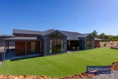  1645 Woodlands Rd Stoneville WA 6081 $1,329,000Located in the family friendly Hills neighbourhood of Stoneville, 1645 Woodlands Road is a spot of executive luxury in a quiet natural location. Expansive, contemporary and sleek, this 2021-built Dale Alcock 4 bed 2 bath home is ideal for someone wanting the balance between modern stylish living and a usable easy-care block perfectly positioned for hobby farming or equestrian activities. 4 bedroom, 2 bathroom 2021-built Brick & Iron Modern chef’s kitchen Butlers pantry/storage Stylish open plan living Study and theatre room RC ducted app-control A/C Paddocks, easy care gardens 200 sqm powered workshop Ablutions/office/bar/storage 5.07-acre level fenced block Entering the home – with soaring vaulted cathedral ceilings, panoramic A-frame windows and light, neutral décor – we are greeted with a picture of contemporary brightness. Set adjacent to the wide foyer, we find the centres of business and pleasure respectively – a cosy yet functional study with plenty of natural light and space for shelving and a bright home theatre room, fitted with A-frame windows and light, dreamy drapes. The beating heart of this beautiful home lies in the modern, stylish chef’s kitchen replete with sleek cabinetry, stainless steel appliances, a walk-in butlers pantry and with a dedicated mud room, storage is a breeze. A gleaming Caesar stone quartz benchtop, warmly toned flooring and steel feature beams both capture the natural elements and crisp clean lines of the open plan living area. The outdoor alfresco is perfectly positioned for indoor/outdoor entertaining, with wide sliding doors leading directly from the kitchen and framed by a coffee rock wall and a shallow oasis of lush green lawn. Manicured to perfection, this grassy area is the perfect spot for children or animals to play safely. The master bedroom is a modern sanctuary – a vast clean space with wide vista views to the fields beyond, soft carpet underfoot and a decadent walk-in dressing room. The master seamlessly blends to the ensuite bathroom, which is decked out with luxurious finishes including a double vanity, a walk-in rain shower and freestanding bathtub. The junior south facing wing features three large bedrooms all with built in robes, a family bathroom with bath, shower, vanity, a separate powder room and a dedicated activity room- a relaxing chillout space for teenagers with plenty of space for games and toys. Located behind the main residence lies a huge 200 sqm powered workshop with extra height rolling doors, concrete flooring, an enclosed office space and ablution area fitted with shower, WC and vanity. This shed is truly the handy man’s dream. This home is full of high-tech easy living features; a shoppers entry from the double garage, LED energy efficient lighting, a Daikin reverse-cycle ducted air conditioning system and smart wiring all add to modern appeal. This 5.07-acre property has great potential for self-sufficiency and is perfect for animal or agriculture lovers, with several enclosed paddocks with gated access ways and a 150,000 litre rainwater tank – ideally positioned for a hobby farm or an expansive productive garden. Site works have been started that can easily be converted to an equestrian arena or the potential pad for a studio/granny flat, (due diligence from the Shire). Set in Kanangra Estate, a prestigious neighbourhood of quality homes, the property is in a convenient location with easy access to local schools, the bustling village of Mundaring with arterial road links offering rural living without compromise. 