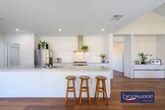  1645 Woodlands Rd Stoneville WA 6081 $1,329,000Located in the family friendly Hills neighbourhood of Stoneville, 1645 Woodlands Road is a spot of executive luxury in a quiet natural location. Expansive, contemporary and sleek, this 2021-built Dale Alcock 4 bed 2 bath home is ideal for someone wanting the balance between modern stylish living and a usable easy-care block perfectly positioned for hobby farming or equestrian activities. 4 bedroom, 2 bathroom 2021-built Brick & Iron Modern chef’s kitchen Butlers pantry/storage Stylish open plan living Study and theatre room RC ducted app-control A/C Paddocks, easy care gardens 200 sqm powered workshop Ablutions/office/bar/storage 5.07-acre level fenced block Entering the home – with soaring vaulted cathedral ceilings, panoramic A-frame windows and light, neutral décor – we are greeted with a picture of contemporary brightness. Set adjacent to the wide foyer, we find the centres of business and pleasure respectively – a cosy yet functional study with plenty of natural light and space for shelving and a bright home theatre room, fitted with A-frame windows and light, dreamy drapes. The beating heart of this beautiful home lies in the modern, stylish chef’s kitchen replete with sleek cabinetry, stainless steel appliances, a walk-in butlers pantry and with a dedicated mud room, storage is a breeze. A gleaming Caesar stone quartz benchtop, warmly toned flooring and steel feature beams both capture the natural elements and crisp clean lines of the open plan living area. The outdoor alfresco is perfectly positioned for indoor/outdoor entertaining, with wide sliding doors leading directly from the kitchen and framed by a coffee rock wall and a shallow oasis of lush green lawn. Manicured to perfection, this grassy area is the perfect spot for children or animals to play safely. The master bedroom is a modern sanctuary – a vast clean space with wide vista views to the fields beyond, soft carpet underfoot and a decadent walk-in dressing room. The master seamlessly blends to the ensuite bathroom, which is decked out with luxurious finishes including a double vanity, a walk-in rain shower and freestanding bathtub. The junior south facing wing features three large bedrooms all with built in robes, a family bathroom with bath, shower, vanity, a separate powder room and a dedicated activity room- a relaxing chillout space for teenagers with plenty of space for games and toys. Located behind the main residence lies a huge 200 sqm powered workshop with extra height rolling doors, concrete flooring, an enclosed office space and ablution area fitted with shower, WC and vanity. This shed is truly the handy man’s dream. This home is full of high-tech easy living features; a shoppers entry from the double garage, LED energy efficient lighting, a Daikin reverse-cycle ducted air conditioning system and smart wiring all add to modern appeal. This 5.07-acre property has great potential for self-sufficiency and is perfect for animal or agriculture lovers, with several enclosed paddocks with gated access ways and a 150,000 litre rainwater tank – ideally positioned for a hobby farm or an expansive productive garden. Site works have been started that can easily be converted to an equestrian arena or the potential pad for a studio/granny flat, (due diligence from the Shire). Set in Kanangra Estate, a prestigious neighbourhood of quality homes, the property is in a convenient location with easy access to local schools, the bustling village of Mundaring with arterial road links offering rural living without compromise. 