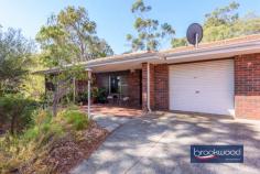  1 Darlington Rd Darlington WA 6070 $549,000 The surprise and delight of this spacious duplex with a flowing floor plan and large backyard make it a compelling opportunity to gain a foothold in the Perth Hills. The neat home sits on an elevated block looking out to a nature reserve, a situation that delivers a daily dawn chorus courtesy of the abundant bird life. Subtle 70s features, an idyllic location, a corner block and a no-fee duplex with a garage combine in an exceptional property. 3 beds 1 bath 2 WC Brick & tile duplex Spacious bedrooms Flowing floorplan OP Kitchen/meals E-facing verandah Expansive backyard Garage w shoppers 1339 sqm crn block A rare opportunity The front door opens into a comfortable, well-proportioned lounge room with a picture window framing classic Hills’ views from its elevated position. A sheltered front porch offers a similar perspective and the perfect spot for morning coffee. A clinker brick feature wall introduces a touch of 70s authenticity and partially separates the lounge from the open-plan kitchen/meals area. The meals area has ample room for a table, and the kitchen is defined by a worktop and integrated breakfast bar atop under-bench cabinets. An electric oven, grill, and hotplates ensure a functional space with plenty of room to cook up a storm. A sliding door leads from the meals area to the shelter of the large back verandah and yard.  A door from the kitchen opens into a spacious walk-through laundry with built-in storage, a separate WC and a shoppers’ entry to the single garage. The family bathroom and three bedrooms are arranged at the north of the plan. The front and rear bedrooms are generously proportioned with built-in or walk-in robes, carpet and ceiling fans. The bedroom at the front of the plan boasts a picture window framing aspects of the garden and reserve. The rear bedroom looks out to the backyard. The family bathroom has a shower tub, vanity, and WC. The home’s garage opens directly into the laundry – a practical and surprising feature in a duplex unit of this vintage. This home sits on over 1339 sqm of land, with the potential for a second access point from Mitchell Road. Approval of the additional access could, in turn, allow for the construction of a workshop or storage space for a caravan or boat. This duplex feels like a detached home and represents an ideal proposition for first-home buyers wanting to get a foot in the Perth Hills or downsizers who still want to have room to garden and space for visitors. 