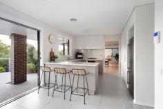  2A The Spur Frankston South VIC 3199 $1,250,000 - $1,375,000 Presenting an alluring lifestyle of exclusivity and coastal elegance, this renovated beachside home effortlessly blends timeless charm with contemporary sophistication. Nestled amidst a picturesque back-drop of lush greenery, a lofty elevation and modern facade forms a bold street presence to this five-bedroom FHSZ home. Delighted by a north-facing light, the dual-storey design delivers families a firm entertaining footprint where everyday living holds focus across a first-floor domain. Alluring with white-washed timber beams and a clean neutral palette, the light-filled level anchors accommodation with an open plan lounge and dining space, and kitchen complete with servery window, stone benchtops and premium-grade appliances. Making use of its elevation sees a private treetop alfresco extend entertaining outwards, while an intimate space for the children remains to the rear with direct Frankston Jamboree Park access. A dreamy master bedroom provides luxury for parents, with a dressing room and stylish ensuite, custom sheers and north-facing orientation. Servicing both family and guests, a main bathroom with stone-topped vanity sits central to three additional bedrooms across the top floor. The glimmer of a gas fireplace warms the downstairs level, where a generous lounge with wet bar, updated main bathroom and fifth bedroom with private alfresco access inspires a guest/teenager retreat, or the potential for short-stay accommodation (SCTA). With reverse-cycle ducted heating and cooling, solid timber floors, custom window furnishings, alarm system, a single garage and architecturally-designed gardens by Colin Hyett Design, this contemporary home sits only moments from Frankston Foreshore and Boat Ramp, Frankston High and Overport Primary School, and Bayside Shopping Centre. 