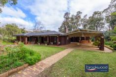  895 Kintore Rd Parkerville WA 6081 Multigenerational and packed to the rafters with family-focussed features, this Parkerville property has been at the heart of an extended family’s life for twenty-three years. Surrounded by 4.7 acres of pasture and bush, the property offers the perfect blend of a family home, a country property and bush living. 4 bedrooms 2 bathrooms 1975-built brick and tile 1 bedroom 1 bath flat UMR Renovated baths & laundry Open-plan kitchen/meals Huge undercover patio Studio + garage + workshop Scheme + tank + bore water 4.7-acres w auto entry gate Multi-generation family haven A pair of imposing front doors open to reveal the soft honey-tones of slate floors and a large, bright foyer. French doors lead to a lounge with timber-look floors, a slow-burning fire, and glazed doors to the front verandah and alfresco entertaining area. Glazing on four sides ensures this room is awash with natural light and filled with views of the surrounding landscape. A home office currently sits off the foyer. This generously proportioned room is fitted with a wardrobe recess, allowing new residents to style it as an additional bedroom; with the main bedroom nearby, it would make an ideal nursery or bedroom for a young child. The main bedroom sits at the front of the plan and boasts storage along two walls, a pair of retro arched windows and reverse cycle air conditioning. A fully tiled floor to ceiling renovated bathroom with pebble feature tiles, a shower, and a vanity brings modern style to the restful and welcoming parents’ retreat. From the foyer, slate tiles continue along a small hall to a walk-in pantry with full-height shelving and cupboards along each wall, providing ample storage for ingredients, appliances, cookbooks and tableware. It sits opposite a galley-style kitchen with timeless white cabinetry, a butler sink, and a timber benchtop with an integrated breakfast bar. A 900 mm Blanco oven brings an industrial edge to the gently country-style kitchen, and a dishwasher and plenty of storage ensure this is a practical workspace with solid family-friendly credentials. The integrated breakfast bar links the kitchen to a lounge/dining area with dual-aspect glazing and flowing movement to the alfresco entertaining area, blurring the distinction between indoor and outdoor living and entertaining. Reverse cycle air conditioning and a slow-combustion fire confirm this room as the year-round heart of the home. Underpinning an impeccable indoor-outdoor layout is the huge paved alfresco entertaining area under a gable roof. This garden-edged area provides ample space for extended family to come together for impromptu meals or festive celebrations and offers a natural meeting point between the principal residence and the self-contained Granny/Aunty/Teenager’s flat. A long verandah extends across the rear of the home with steps leading to a terrace and expanse of lawn. A fenced area has been used to contain a spa and above-ground pool and could do so again. Two junior bedrooms with reverse cycle air conditioning, open shelving, and wardrobes feature timber floors and a neutral colour palette. They are large enough to accommodate a king-size bed. The junior bedrooms share a fully tiled, renovated family bathroom and a separate WC. Completing the layout in the junior wing is a walk-through laundry with a door to the spacious flat set under the main roof. The internal door linking the home and flat opens into a dining room with a kitchen on one side. Timber look floors extend across the flat. A family room with a slow-combustion fireplace and reverse cycle air conditioning benefits from views of the garden and large windows on two sides. With its own front door, residents of the flat enjoy an independent lifestyle while retaining a connection to the family in the principal residence. The main bedroom is filled with lush garden views and features a walk-in robe and storage cupboard along with the modern ensuite with shower vanity and WC. Surrounded by 4.7 acres of pasture and bush, the property boasts numerous outbuildings, including an air-conditioned two-room studio suited to myriad uses, a two-car garage with power and a powered 10m x 10.5m workshop with a small mezzanine storage area and double doors for in-out access. Numerous nut trees, small orchard, raised beds which provide space for growing vegetables, and a chicken coop provides shelter for feathered friends. A single paddock is home to the current owners’ goats. Whatever the shape of your family and your vision of the life you create together, this impressive property has what it takes to bring that vision to life. Local schools, the bustling village of Mundaring, sports and outdoor activities, and transport links are all within easy reach. 