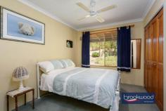  9 Clipson Cres Mundaring WA 6073 $899,000 Hidden behind a lush, vibrant front garden, this home is a true sanctuary in the serene, glen-like setting of the prestigious Noblewood Estate. From the moment you arrive, the home invites you in with its timeless charm and thoughtful design. With schools, parks, the bridle trail and Mundaring Village all within easy reach, it is perfect for families who value comfort, convenience, and a connection to nature. 4 bedrooms 2 bathrooms 2000-built brick and iron Central open-plan living Indoor-outdoor floorplan Elevated alfresco entertain RC air con & ceiling fans Drive-in gated rear access Tandem carport storeroom Landscaped 2001 sqm lot Walk to school and park Designed to celebrate light, space, and the inimitable beauty of the Perth Hills, this delightful home offers a wide south-facing verandah, a perfect perch to watch birds flit and play in the front garden, and a deep, sheltered patio, an elevated site for relaxing and entertaining against a backdrop of majestic gums standing sentinel at the property’s rear boundary. Large windows across the rear of the home invite a beautiful quality of natural light into the interior spaces. To one side of the tiled entrance, a well-considered layout unfolds, featuring a convenient guest powder room, a cozy minor bedroom, and the principal suite, providing a peaceful retreat with plenty of space for relaxation. At the heart of the home lies the open-plan kitchen, meals area, and family room, a bright and inviting space designed to bring loved ones together. Natural light floods the area, accentuating its spaciousness and warmth. Every season is a delight, with reverse-cycle air and a ceiling fan. One corner of this open plan features a kitchen equipped for culinary creations. Anchored by a stone-topped bench and integrated breakfast bar, it is a cook’s delight. A walk-in pantry and cabinetry in a soft cream finish provide ample storage and ensure everything has its place. Meal prep is a breeze, thanks to an electric oven, gas hob, and dishwasher that make clean-up effortless. Comfort, elegance, and considered design converge to create a haven for every family member. This property is tailored to meet the demands of modern living with an ideal balance of privacy and shared spaces. The principal bedroom is a blissful retreat at the rear of the plan. North-facing windows flood the space with filtered light, offering a serene start to each day with breathtaking views of the surrounding landscape. This sanctuary, humming with an air of comfort and calm, is complemented by a private ensuite and a spacious walk-in wardrobe. The design effortlessly accommodates family life with a junior wing that extends from the central living area – comprising two carpeted bedrooms with built-in robes, a well-appointed family bathroom, and a convenient walk-through laundry. The third junior bedroom is currently styled as a home office and would make an ideal guest room or nursery for a young child. A large walk-in linen press adds extra practicality, ensuring every corner of this home is as functional as stylish. Step out onto the north-facing verandah, where you’ll find an ideal spot to entertain, dine alfresco, or bask in the tranquil ambience of your private oasis. For those who love to entertain, the large paved and covered outdoor space offers an inviting area to gather with friends and family. Whether it’s a casual weekend barbecue or a more formal soirée, this elevated space, looking across gardens to a landscape dotted with eucalypts and grass trees, will make outdoor entertaining a joy, no matter the occasion. With every element referencing the stunning Hills setting – luminous interiors, seamless indoor-outdoor connections and relaxed style – this home is designed to elevate everyday living while maintaining a sense of connection and harmony. 