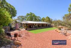  80 Benrua Rd Clackline WA 6564 $680,000 Escape the hurly-burly of city living in this beautifully presented country getaway on 2-hectares in a quintessentially Australian landscape. Designed for rural living, the property boasts fenced paddocks, horse shelters, a powered workshop, a shaded south-facing garden and a spacious chicken coop with a run. The cedar and iron home is a charming blend of modern country and retro flair, creating an inviting and whimsical interior. It’s easy to imagine a happy life lived at a gentle pace in this fantastic country cottage. 3 bedrooms 1 bathroom 1989-built cedar and iron Wrap-around verandahs Principal bed semi ensuite SC fireplace split air-con Flexi-use office/activity rm Paddocks with laneways Workshop & 2-car carport 2-hectares/4.9 acres fenced Classic country retreat Occupying in an iconic Australian setting, this charming rural property offers a serene escape from the pace of city life. The west-facing verandah, shaded by a lattice, provides a breathtaking vantage point for sunsets over the paddocks. At its southern end, a shaded retreat offers a cool, calm sanctuary on warm summer evenings, ideal for alfresco dining under a canopy of stars. The home is designed for relaxed living. A slow-combustion fireplace anchors the open-plan living area, while a timber-lined pitched ceiling and reverse-cycle air conditioning create a cozy yet airy atmosphere. The pine kitchen, complete with an electric wall oven, four-burner hob, built-in pantry, and ample cabinetry, is as practical as it is charming – a window above the sink frames views of the glen-like, south-facing garden. The main bedroom is a tranquil haven, where a large window draws in natural light and showcases the beauty of the surrounding paddocks and gum trees. Neutral tones, a ceiling fan, a walk-in robe, and a semi-ensuite create a comfortable and stylish retreat. Two additional bedrooms, one with a ceiling fan, are conveniently located off the central hallway, which leads to a versatile, light-filled room. Currently styled as a home office, this adaptable space, with direct access to the carport and fenced backyard, could serve as a guest suite, entertaining area, or activity room. Beyond the interiors, the property truly shines. A powered workshop with a lean-to offers space for projects or equipment storage, while three fenced paddocks, some with shelters and water, offer excellent facilities for livestock. A spacious chicken coop and run promise fresh eggs and a taste of farm-to-table living. Whether you’re dreaming of a simpler life immersed in nature or seeking a tranquil country retreat to call home, this Clackline gem offers the perfect balance of indoor comfort and outdoor freedom. With its peaceful setting, versatile spaces, and undeniable charm, this is a rare opportunity to embrace the beauty of rural living. 