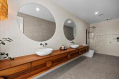  22 Hermitage Drive Moama NSW 2731 $1,685,000 to $1,795,000 This exquisite build is noticeably extravagant from the street and from the moment you walk through the front door. From the three metre high ceilings to the six metre long stone kitchen island bench, every little detail has been well thought out and presented exceptionally. As you walk through the front door you enter an impressive open plan kitchen, living and dining area. The kitchen is fully equipped with high quality Bosch appliances, an induction cooktop and a dishwasher. Additionally there is a butlers pantry for the storage of a fridge and appliances. The kitchen has a substantial amount of storage under the stunning six metre stone island bench and overhead cupboards. There is also a servery with a stone bench top and a bifold window perfect to enjoy an afternoon champagne or a morning coffee overlooking the pool and backyard. On the left hand wing of the home you will find three spacious bedrooms with built-in robes, block out blinds and ceiling fans. The elegant main bathroom has floor to ceiling tiles, a stone bath and stand-out high-class ABI brushed copper tapware. Following on down the hall is a separate powder room, a study area with a built in desk and a luxury laundry with extensive storage. In the opposite wing you will find the main suite and second living area or parents retreat. The main bedroom is overflowing with space and overlooks the inviting 8x4 magnesium solar heated pool through sliding doors. The master suite also has a generous sized walk-in-robe and ensuite with floor to ceiling tiles, custom built 6m timber vanity with ABI brushed copper tapware. Outside there is a huge outdoor area fitted with blinds, an outdoor kitchen with BBQ and a Jet Master fireplace perfect for the cooler nights. All lawns and gardens are low maintenance and are fitted with automatic sprinkler systems. There is an additional toilet outside with a vanity perfect for when entertaining or using the pool, avoiding the need for people to go inside. The garage has a double and single doors with 4 metre high clearance, perfect for the storage of a caravan and/or boat along with 4 additional car spaces. The home is kept comfortable throughout the year with commercial double glazed and louvre windows, evaporative cooling and ducted gas heating. Fitted with 8.2 kw solar panels to keep your energy bills at a minimum. 