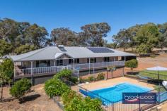  117 O'Driscoll St Bakers Hill WA 6562 $899,000 Blending elegant design with the tranquillity of nature, this magnificent Queenslander-style home redefines country living. Open-plan living, a below-ground pool, a powered workshop and a beautiful garden setting combine to create a dream 2.6-acre sanctuary, offering the perfect canvas for your family’s most cherished memories. 4 bedrooms 2 bathrooms 2007-built Hardi and iron Wrap-around wide verandahs Gourmet kitchen & island Home theatre Ducted air con, insulation Salt-water B/G swimming pool 9m x 6m powered workshop 2.6-acre country estate This picturesque Queenslander sits proudly amongst thoughtfully arranged plantings, orchards and paddocks. The home’s classic wide verandahs and welcoming pitched portico immediately evoke a sense of timeless elegance and arrival. Step inside to discover the honeyed tones of Blackbutt timber flooring. The open-plan living space impresses with its soaring raked ceiling and bright, airy atmosphere – a sanctuary where you can exhale and unwind. Year-round comfort is ensured with a reverse-cycle air conditioner for summer respite and a magnificent slow-combustion burner with wetback system that becomes the heart of the home during winter evenings. The gourmet kitchen features shaker-style cabinetry that provides abundant storage and expansive preparation areas. The substantial breakfast bar and island bench create perfect gathering spaces, while premium appliances, including the show-stopping 900mm Artuzi oven, inspire culinary creativity. Adjacent to the kitchen, elegant French doors reveal a dedicated home theatre with a projector and screen – an exceptional space for regular movie nights. The sumptuous primary suite is a king-sized haven with a generous walk-in robe and a classically appointed ensuite with a deep soaking tub, shower and private WC. A door opens to a private decked verandah – your oasis for savouring morning coffee amidst native bird-attracting gardens and the soothing sounds of a tranquil pond. Three additional bedrooms offer spacious and spacious privacy at the residence’s rear. Each room boasts premium Tasmanian oak blinds, plush 100% wool carpeting and built-in storage. A well-appointed family bathroom and substantial laundry complete this wing, ensuring comfort and functionality. This exceptional property anticipates your every desire with thoughtful amenities throughout. Ducted evaporative air conditioning maintains perfect comfort, while the integrated solar hot water and photovoltaic systems harness nature’s energy, reducing environmental impact and costs. The property connects to scheme water, supplemented by discreetly positioned 2500L water tank. An eight-zone automatic reticulation system maintains the lush landscape with minimal effort. The sparkling below-ground salt-water pool offers a refreshing retreat during warmer months. A sheltered deck creates the ideal setting for alfresco entertaining and casual gatherings beneath the stars. Embrace the authentic Hills lifestyle with meticulously planned outdoor spaces, including fenced paddocks, a charming chicken coop and a productive vegetable garden that promises farm-fresh bounty throughout the seasons. The substantial 9m x 6m powered workshop – complete with dedicated bathroom facilities and water connection – provides endless possibilities for projects, hobbies or additional storage. Located moments from local amenities and the renowned Bakers Hill Bakery, this remarkable property offers the perfect balance of seclusion and convenience. The secret of this extraordinary Queenslander awaits your discovery – an unparalleled opportunity to embrace the country lifestyle you’ve always envisioned. 