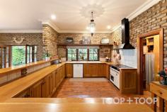 94 Tanahmerah Rd Balhannah SA 5242 Timeless elegance radiates with abundance around this stunning Carey Gully stone and brick residence surrounded by gorgeous English cottage gardens and the rolling hills of Balhannah. An exquisite marble entrance complete with delicate lead light windows opens up to a breathtaking home designed to provide both luxury and comfort, while amplifying the stunning surrounds of designer garden and natural bushland. The entrance of the residence opens up to an expanse of living and dining spaces, all surrounding a warm and light filled atrium at the heart of the home. A formal lounge and dining room present a picturesque space to entertain in comfort while the glass and timber atrium, equipped with underfloor heating is a testament to the meticulous attention to detail and functionality that characterise this home. The timeless parquet floors that flow throughout the home are complimented by the floating floorboards that grace the kitchen and dining areas. Four generous bedrooms surrounding the central atrium offer ample space for living and storage along with charming views of the surrounding scenery, while the majestic master suite boasts an elegant bathroom and spacious walk-in robe. The flexibility of the layout allows for a configuration of three bedrooms or the option to create a study space for those seeking a home office. Moving through the retreat style atrium, a grand American Oak kitchen hosts a large walk-in pantry, Belling oven and exhaust fan, and a Miele dishwasher. This space is enhanced by a spacious casual dining area featuring a Coalbrook Dale Wood Fire heater and surrounding scenic views to the manicured garden and rolling hills. Looking through the numerous, generous windows, an expansive verandah highlighted by hand-made terracotta edging tiles wraps around the home. Its 40 solar panels, ducted air conditioning and vacuum system further ensure eco-friendly, efficient and comfortable living. Beyond the immediate residence, the property unfolds into 25 acres of scenic beauty featuring 2 acres of meticulously maintained English Cottage style gardens. An automatic watering system and fully lit garden with lanterns and floor lights enrich the natural botanical splendour. At the southern aspect of the home, a large, light filled conservatory, surrounded by floor to ceiling glass walls, sets the stage for alfresco dining. With a fully-functional kitchen, the curated entertainment space caters for grand occasions, with space to seat sixty people in a round dining table setting. The exceptional functionality of the property is supported by a billabong, dam, bore and a valuable water license, adding convenience and potential to the opportunity. A farm shed, woodshed, and a double garage with automated doors offer abundant storage. The plot also homes 100 nut trees and 20 cherry trees, contributing to the landscapes breathtaking natural charm while delivering stunning views of native bushland. Set against this picturesque backdrop, this stunning residence is a perfect blend of classic charm and modern refinement, offering an idyllic retreat to unwind and entertain in style. This is a property that perfectly encapsulates the essence of luxury country living while remaining a testament to functional design. Location Highlights: + Situated on the scenic Mt George side of Balhannah + 10 minutes commute to the city + Close to iconic venues such as the Stanley Bridge and Uraidla Hotels, Hahndorf Hill winery and Ambleside Distillery +Zoned for Uraidla, Bridgewater and Oakbank Primary Schools, plus close to the Hills Christian and Cornerstone Colleges. 