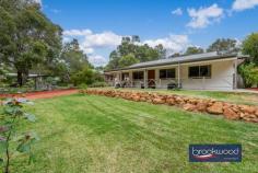  4A Darkan St Mundaring WA 6073 $799,000 Discover this beautifully presented cosy cottage – an ideal first home for young couples, families or an excellent option for downsizers still wanting space to garden and a workshop for tinkering. This home sits within easy reach of the bustling Mundaring village, has good access to public transport and is a short drive from Midland yet boasts a green and leafy Hills setting. 3 bedrooms 1 bathroom 1989-built Hardi and iron Spacious modern kitchen Central open-plan living Front and rear verandahs Bright neutral interiors Entertainers’ backyard Powered garage/w’kshop Landscaped 969 sqm lot Immaculate first home A wide, east-facing verandah looking over a lush garden and lawn offers a charming, calm welcome to this beautifully presented Mundaring home. The front door opens into a living zone awash with light from windows on three sides. A well-appointed modern kitchen with marble benchtops sits to the rear of this open-plan living zone and flows seamlessly to the back verandah, a verdant lawn and a grape-strewn arbour tucked away in the backyard. A soft, neutral palette and lots of natural light bring an airy freedom to the living zone. The kitchen boasts a wealth of soft-close cabinets and drawers, an integrated coffee machine and microwave, a dishwasher and an electric wall oven and cooktop. Reverse cycle air conditioning brings year-round comfort to this area, and easy indoor-outdoor movement ensures an alfresco lifestyle. A central hall with built-in storage leads from the shared living zone to a walk-through laundry with good storage and a worktop, a family bathroom with shower, vanity and bathtub, a separate WC and three bright and inviting bedrooms. The main bedroom is generous, looks across the front verandah and garden and has a R/C S/S air conditioning and double built-in robe. Both junior rooms have built-in robe recesses and one bedroom is fitted with reverse-cycle air conditioning. A powered workshop/garage with a concrete floor and double roller doors sits at the end of the driveway. The backyard feels like a wonderfully private hideaway with a wide verandah looking out onto a lush garden and lawn, a gorgeous grape-covered arbour and blossom-covered tree.  This is a picture-perfect backyard, neither too big nor too small, with space for kids and pets to run and play, secure storage in the workshop/garage, and ample space for alfresco entertaining. 