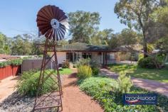  6A Waylen Rd Darlington WA 6070 $799,000 This thoughtfully renovated duplex exemplifies contemporary Australian living, where stone walls and landscaped gardens frame an entrance to refined interiors and exceptional outdoor entertaining. 2 bedrooms 1 bathroom Skillfully updated duplex Fantastic landscaped gdn Open plan, high ceilings Generous master w/ BIR Huge entertaining patio Drive-in access to the rear Space to build a workshop Easy-care ¼ ac property Super convenient locn The open-plan kitchen and living room anchor the home, with refinished jarrah floors extending beneath high ceilings. A bright neutral palette amplifies the east-facing orientation, whilst a corner window dressed in plantation shutters draws natural light deep into the plan. Comprehensive climate control – reverse-cycle air conditioning, ducted evaporative cooling, and a slow-combustion fireplace – ensures year-round comfort. The kitchen’s U-shaped configuration maximises both workspace and storage. An integrated breakfast bar provides casual dining, whilst soft white cabinetry above and below offers ample storage. Electric cooking facilities await culinary adventures. The principal bedroom provides a serene retreat with high ceilings and plantation shutters, maintaining design continuity. Jarrah flooring throughout delivers the warmth and character of this uniquely Western Australian timber, complemented by mirror-front built-in robes and generous natural light. A junior bedroom, currently styled as a home office and studio space, demonstrates the property’s adaptability. Garden views and quiet positioning make this an ideal workspace, with flexibility to accommodate changing needs. The family bathroom showcases contemporary finishes – textured tiles and a large shower that elevates daily routines. A separate toilet and updated walk-through laundry with shaker-style cabinetry complete the interior. Outdoor entertaining takes centre stage with a sizeable paved area beneath a high gable roof. An overhead fan and screens enhance year-round usability, whilst fenced landscaped gardens ensure privacy. A tranquil pond, raised garden beds, and a practical garden shed create both visual appeal and functional growing opportunities. The quarter-acre block delivers exceptional space and versatility. A gated driveway provides secure access to paved storage suitable for a trailer or a boat, before passing a chicken coop to reach an ideal workshop site with three-phase power and water already connected – a rare combination offering immediate utility and future potential. In sought-after Darlington, this property balances character with contemporary convenience. The comprehensive renovation has created a home that balances style with practicality, offering quality finishes and thoughtful design throughout. With its blend of indoor and outdoor living opportunities, established gardens, and versatile spaces, this duplex represents a well-considered choice for those seeking a distinctive home with genuine character and enduring appeal. 