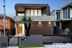  39 Victor Avenue Picnic Point NSW 2213 Positioned in one of the area's most prestigious addresses, this double-brick architectural triumph is a celebration of design, scale, and light. From the soaring void and sweeping staircase on arrival to the tranquil atrium with its sculptural feature olive tree, every element has been curated to evoke a sense of luxury and timeless elegance. Bathed in northern light and designed for grand entertaining, this is a residence of rare distinction. Property Flyover: - Double-brick construction with an architecturally striking façade, anchored by a sculptural Blackboy tree at the front. - Prestigious "Victor Avenue" address surrounded by premium homes. - Breathtaking entry with a dramatic void, grand staircase, and statement atrium featuring an established olive tree. - Expansive main lounge and dining area with open-plan design, soaring ceilings, feature fireplace, and remote-controlled curtains. - Multiple living zones, including formal and informal lounges - ideal for larger families. - Four high-end bathrooms appointed with premium fixtures and bespoke finishes. - Elegant curves and extensive banks of north-facing windows, flooding interiors with natural light and a sense of calm. - Five luxurious bedrooms, including a palatial master suite with a hotel-inspired ensuite and custom walk-in robe. - Showpiece stone kitchen with butler's pantry and expansive island bench - designed for effortless entertaining. - Enormous full-width alfresco with built-in kitchenette, overlooking a sparkling inground pool and manicured grounds. - Full outdoor bathroom for ultimate poolside luxury and convenience. - Ducted air-conditioning, CCTV, keyless entry, and smart home features. - Secure double garage with premium storage solutions, plus remote-operated front gate for further secure off-street parking. Sell Smarter ...ask a Local 